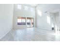 Spacious living room with high ceilings, large windows, and an open floor plan featuring tiled floors at 19801 W Badgett Ln, Litchfield Park, AZ 85340