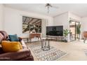 Bright living room featuring a large window, leather sofa, and stylish rug at 19975 N Crescent Way, Surprise, AZ 85374