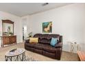 Cozy living room with comfortable leather sofa, stylish decor, and ample natural light at 19975 N Crescent Way, Surprise, AZ 85374