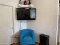 Stylish living room featuring a modern blue chair, decorative art, and a mounted TV at 2070 W Klamath Ave, Apache Junction, AZ 85119