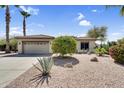 Charming single-story home features a desert-landscaped front yard and an attached two-car garage at 21141 E Stirrup St, Queen Creek, AZ 85142
