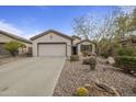 Single-story home showing a paved driveway, two-car garage, desert landscaping, and neutral-toned stucco exterior at 2544 W Pumpkin Ridge Dr, Anthem, AZ 85086