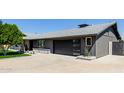 Elegant home featuring a modern dark garage door with sleek horizontal windows and gray exterior at 3137 N Granite Reef Rd, Scottsdale, AZ 85251
