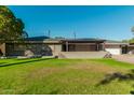 Charming single-story home featuring well-kept front yard and covered porch with stone accents at 346 E Highland Ave, Phoenix, AZ 85012