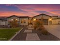 Beautiful front yard with desert landscaping, a green lawn, and brick pavers leading to the front door and garage at 3502 E Hazeltine Way, Queen Creek, AZ 85142