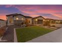 Well-maintained front yard with desert landscaping, a green lawn, and a paved driveway leading to a two-car garage at 3502 E Hazeltine Way, Queen Creek, AZ 85142