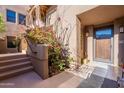 Inviting entrance with desert landscaping, stairs to upper level and front door at 36601 N Mule Train Rd # B14, Carefree, AZ 85377