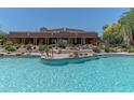 Community pool surrounded by desert landscaping, lounge seating and a covered building at 36601 N Mule Train Rd # B14, Carefree, AZ 85377
