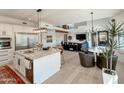 Open concept kitchen and living room with stainless steel appliances, modern lighting, and neutral finishes at 3811 N 64Th St, Scottsdale, AZ 85251