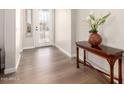 Inviting foyer with wood-look flooring, stylish console table, and decorative glass front door at 4086 E Narrowleaf Dr, Gilbert, AZ 85298