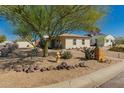 Quaint single-story home landscaped with cacti, trees, decorative rocks, and a vibrant blue sky at 4539 N 9Th Ave, Phoenix, AZ 85013