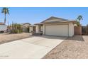 Well-maintained home with desert landscaping, wide driveway, and two-car garage at 519 W Palomino Dr, Chandler, AZ 85225