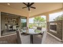 Covered patio with a fireplace and outdoor dining space, perfect for entertaining and enjoying the views at 583 E Peach Tree St, Queen Creek, AZ 85140