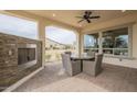 Spacious covered patio with fireplace and views of the well manicured lawn and garden at 583 E Peach Tree St, Queen Creek, AZ 85140