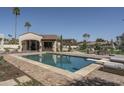 Sparkling pool features a diving board, an outdoor kitchen, and comfortable lounge chairs, perfect for relaxation at 8817 N 58Th Pl, Paradise Valley, AZ 85253