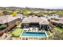 A stunning aerial view of a backyard featuring a sparkling pool, spa, putting green, and outdoor lounge area at 9440 N Sunset Rdg, Fountain Hills, AZ 85268
