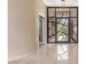 Inviting foyer with a modern glass front door, travertine floors, and a view into the front courtyard at 9440 N Sunset Rdg, Fountain Hills, AZ 85268