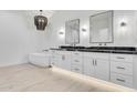 Elegant bathroom featuring a standalone tub, dual vanity, and modern chandelier at 1602 E Cloud Rd, Phoenix, AZ 85086