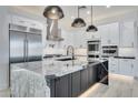 Modern kitchen featuring marble countertops, stainless steel appliances, and stylish lighting at 1602 E Cloud Rd, Phoenix, AZ 85086