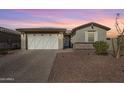 A clean exterior view of single-story home with desert landscaping and a paved driveway at 17286 W Running Deer Trl, Surprise, AZ 85387