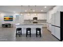 Bright, open kitchen featuring a center island with counter seating and modern stainless steel appliances at 17286 W Running Deer Trl, Surprise, AZ 85387