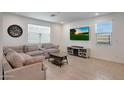 Cozy living room with neutral decor, tiled flooring, and large windows for natural light at 17286 W Running Deer Trl, Surprise, AZ 85387