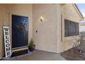 A stylish navy blue front door enhances the curb appeal of this inviting home with desert landscaping at 18665 N 70Th Dr, Glendale, AZ 85308