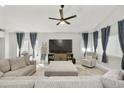 A cozy living room with a large sectional couch, complemented by a ceiling fan and ample natural light at 18665 N 70Th Dr, Glendale, AZ 85308