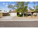 Charming single-story home featuring a well-maintained front yard with desert landscaping and mature trees at 20602 N 31St Dr, Phoenix, AZ 85027