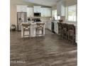 Bright and open kitchen features wood-look tile flooring, white cabinetry, and stainless steel appliances at 2634 E Fountain St, Mesa, AZ 85213