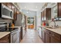 Well-lit kitchen featuring stainless steel appliances, wooden cabinets, and easy access to the outdoor patio at 2910 E Avenida Olivos --, Phoenix, AZ 85016