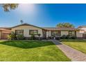 Charming single-story home features a well-manicured lawn and inviting brick pathway at 3016 N 49Th St, Phoenix, AZ 85018