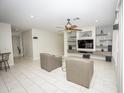 Spacious living room featuring tile flooring, modern fan, and a built-in entertainment center at 35317 N 31St Dr, Phoenix, AZ 85086