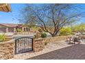 Inviting front patio with stone accents and an iron gate, perfect for outdoor relaxation and curb appeal at 41624 N Anthem Ridge Dr, Anthem, AZ 85086