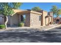 Beautiful home exterior with a stone facade, desert landscaping, and a tile roof at 4241 N Pebblecreek Pkwy # 54, Goodyear, AZ 85395