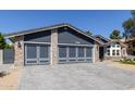 Exterior shot highlighting the spacious three-car garage with brick accents and modern gray doors at 4536 E Beck Ln, Phoenix, AZ 85032