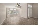 Bright living room features wood-look tile floors, large windows with plantation shutters, and ceiling fan at 4536 E Beck Ln, Phoenix, AZ 85032