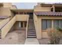 Southwest-style townhome featuring private entrance stairs, tan stucco exterior, and red tile roofing at 4901 S Calle Los Cerros Dr # 236, Tempe, AZ 85282