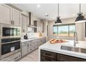 Modern kitchen features stainless steel appliances, gray cabinetry, and a large island with a sink at 544 E Amber Sun Dr, Phoenix, AZ 85086