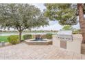 Backyard showcasing a built-in grill, water feature, lush greenery, and scenic views of the golf course at 623 E Peach Tree St, Queen Creek, AZ 85140