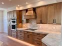 This modern kitchen features custom wood cabinets, stainless steel appliances, and marble countertops at 7955 E Chaparral Rd # 34, Scottsdale, AZ 85250