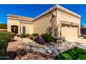 A charming home with a tan exterior, well-kept landscaping, and a two-car garage at 8850 W Piute Ave, Peoria, AZ 85382