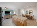 Open-concept layout featuring a kitchen island connecting to a dining and living area at 11121 E Onza Ave, Mesa, AZ 85212
