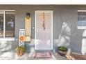 Welcoming front porch featuring a decorative door with stylish decorations and potted plants at 11446 W Hidalgo Ave, Tolleson, AZ 85353