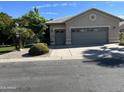 Two-car garage featuring neutral paint, decorative windows, and well-maintained landscaping in a suburban neighborhood at 15385 W Indianola Ave, Goodyear, AZ 85395