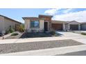 Charming single-story home featuring stone accents, a two-car garage, and low maintenance desert landscaping at 17893 W Indigo Brush Rd, Goodyear, AZ 85338