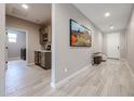 Bright hallway with wood-look tile flooring, featuring a built-in bar and an art display at 17893 W Indigo Brush Rd, Goodyear, AZ 85338