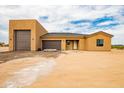 A new stucco home has a three-car garage and desert landscaping at 31114 W 213Th Ln, Wittmann, AZ 85361