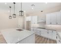 Bright kitchen features white cabinets, stone countertops, and modern pendant lighting at 31114 W 213Th Ln, Wittmann, AZ 85361