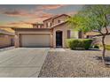 Charming two-story home with a well-maintained front yard, large driveway and a two car garage at sunset at 314 N 79Th Pl, Mesa, AZ 85207